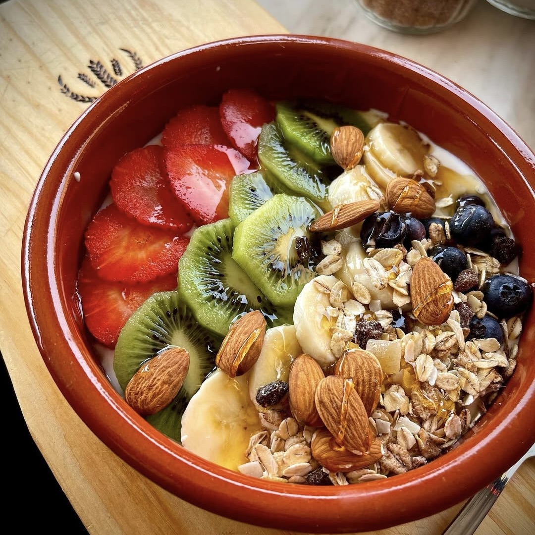 Desayuno fresco y saludable con yogur natural y proteínas, frutas de temporada, semillas y nueces como almendras, y copos de avena de calidad en Tutti Sensi, Portals Nous, Mallorca